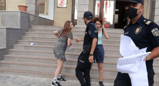 Policemen taking the posters away from the activists, Baku, August 4, 2021. Screenshot: Meydan TV, http://www.youtube.com/watch?v=Sm9Wy_44uWs