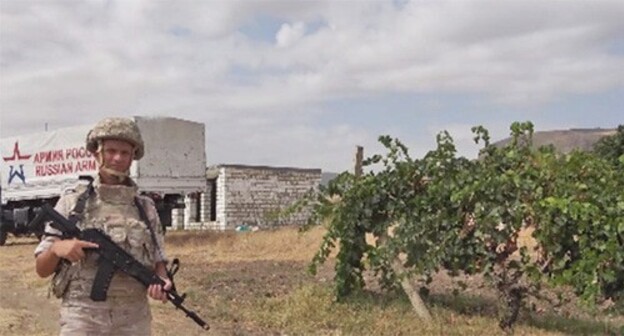 A Russian peacekeeper protects grape pickers. Photo from the official website of the Russian Ministry of Defence https://mil.ru