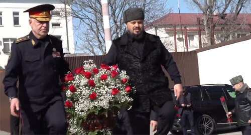 Ruslan Alkhanov, the Chechen Minister of Internal Affairs, and Abuzaid Vismuradov, Deputy Prime Minister of Chechnya, carry flowers to the memorial to the fallen police officers on the Defender of the Fatherland Day. February 23, 2022. Screenshot of the video by the Chechen Ministry of Internal Affairs https://www.instagram.com/p/CaUYCEtocad/