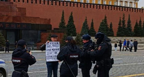 Policemen talk with Oleg Orlov during his picket in Moscow on April 10, 2022. Photo: HRC ‘Memorial’, https://t.me/polniypc/2219