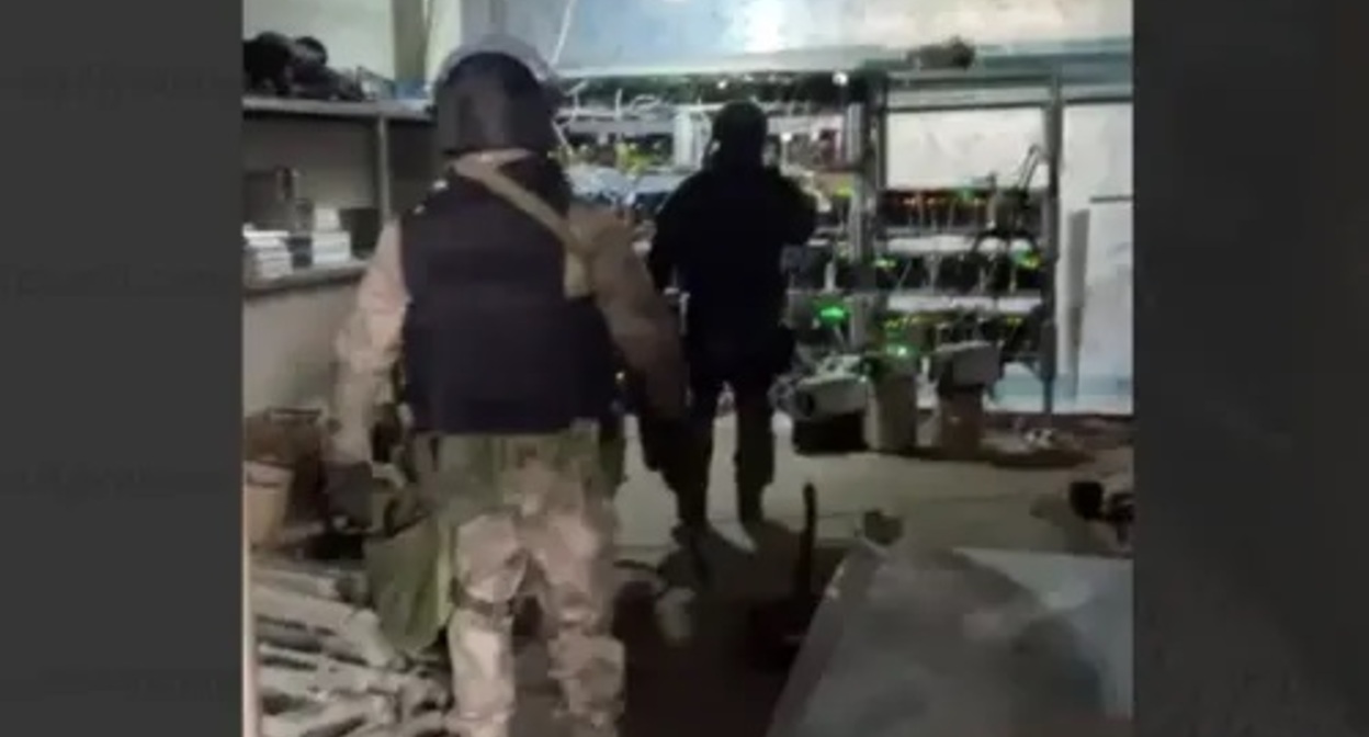 Law enforcers at a mining farm. Image made from video posted by ‘Chernovik’ Telegram-Channel; July 2, 2022, https://t.me/chernovik/33276