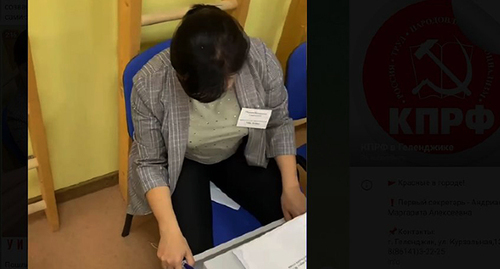 The deputy chairman of the election commission hides ballot papers already filled out for one of the parties under her on a chair. Screenshot: t.me/kprf_gel
