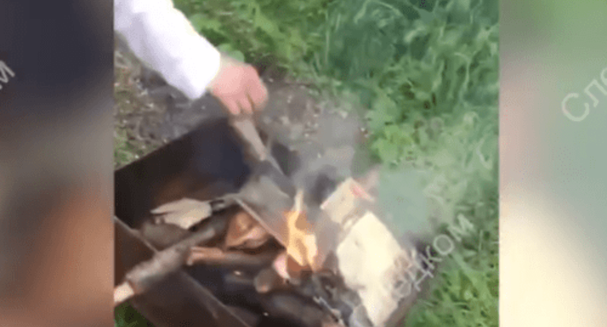 A young man puts the New Testament into the fire in a portable grill. Screenshot of the video posted by the Branch for the Stavropol Territory of the Investigating Committee of the Russian Federation on May 3, 2024 https://t.me/su_skr26/3115