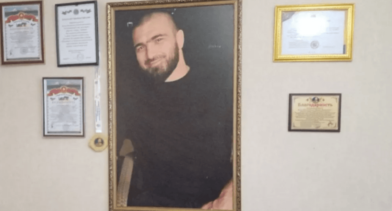 Kurban Dalgatov's photo in his parents' house. Photo: "Chernovik", https://chernovik.net/news/zakryl-kurtkoy-obzor-videokamery-i-telo-kurbana-potaschili-vniz